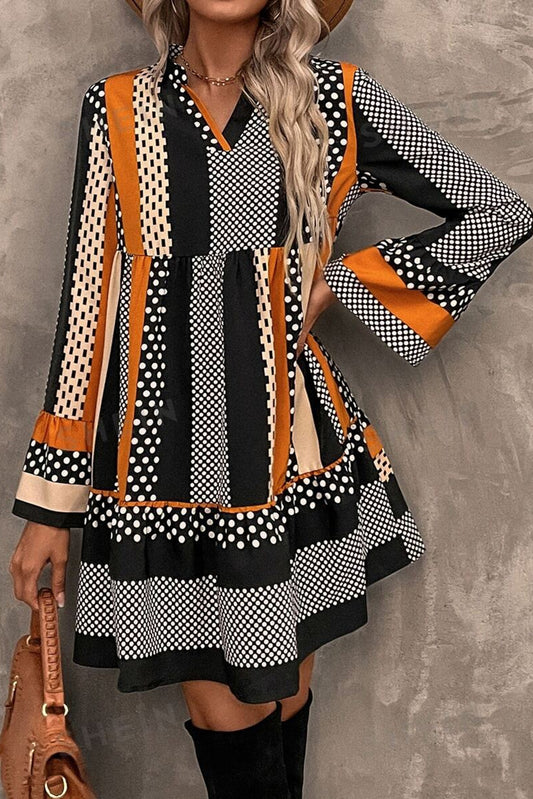 Woman wearing a patterned dress with long sleeves against a gray background